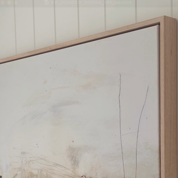 Abstract art piece with a wooden frame on a white wall.