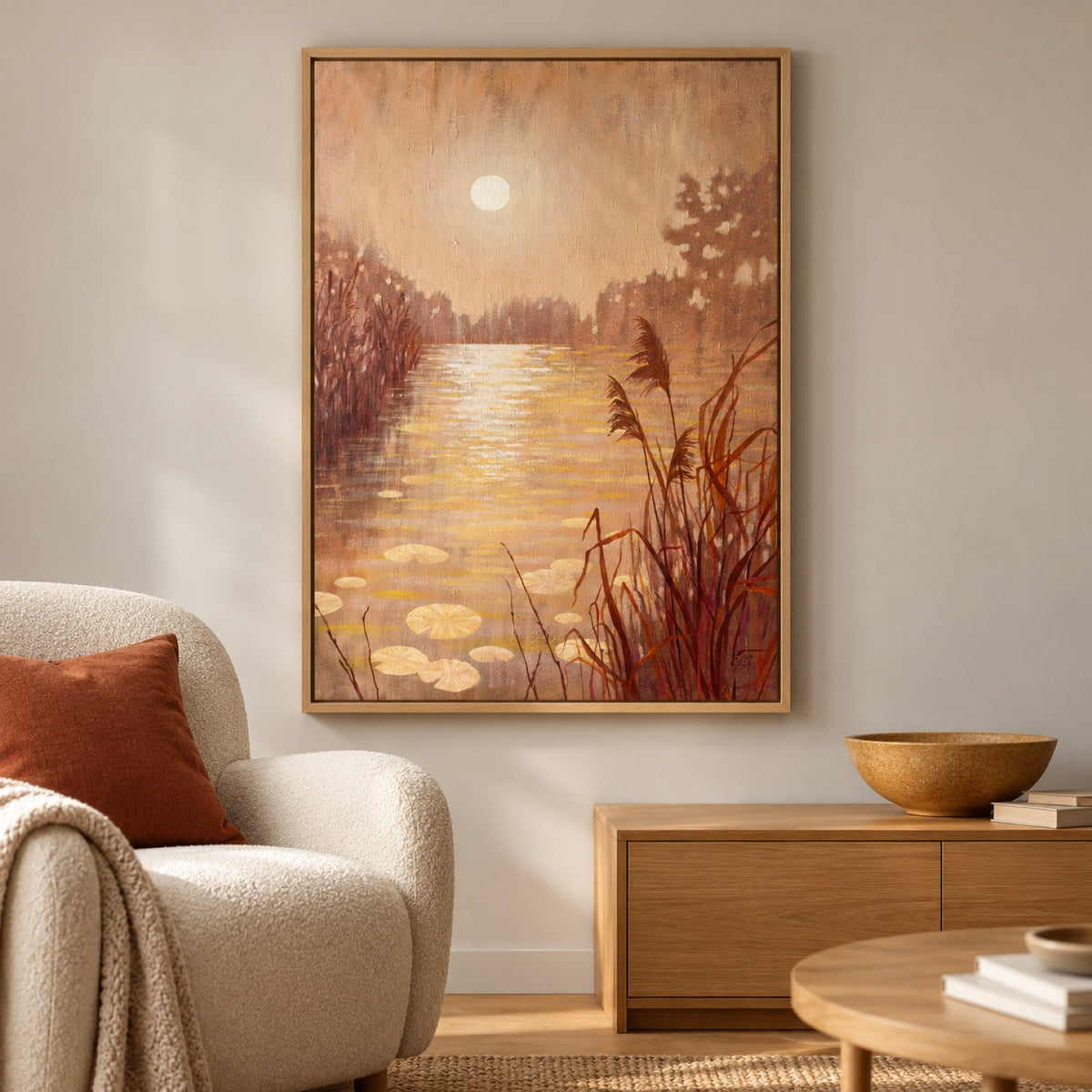Pond With Reeds At Sunset in an oak frame beside an ivory chair with rust cushion and ochre ceramics.