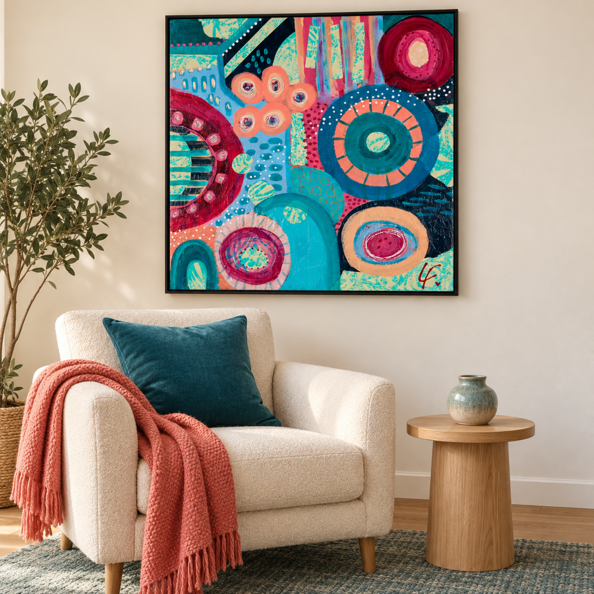 Rhythms of Colour by Lindy Farley in a black frame above a cream armchair with teal and coral textiles.