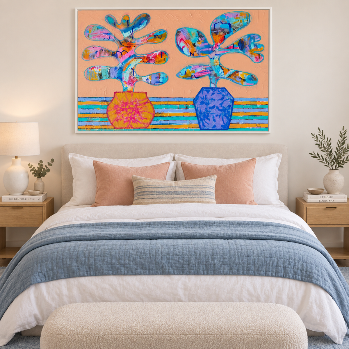 Thelma and Louise by Lindy Farley in a white frame above a cream bed with blue and peach textiles.