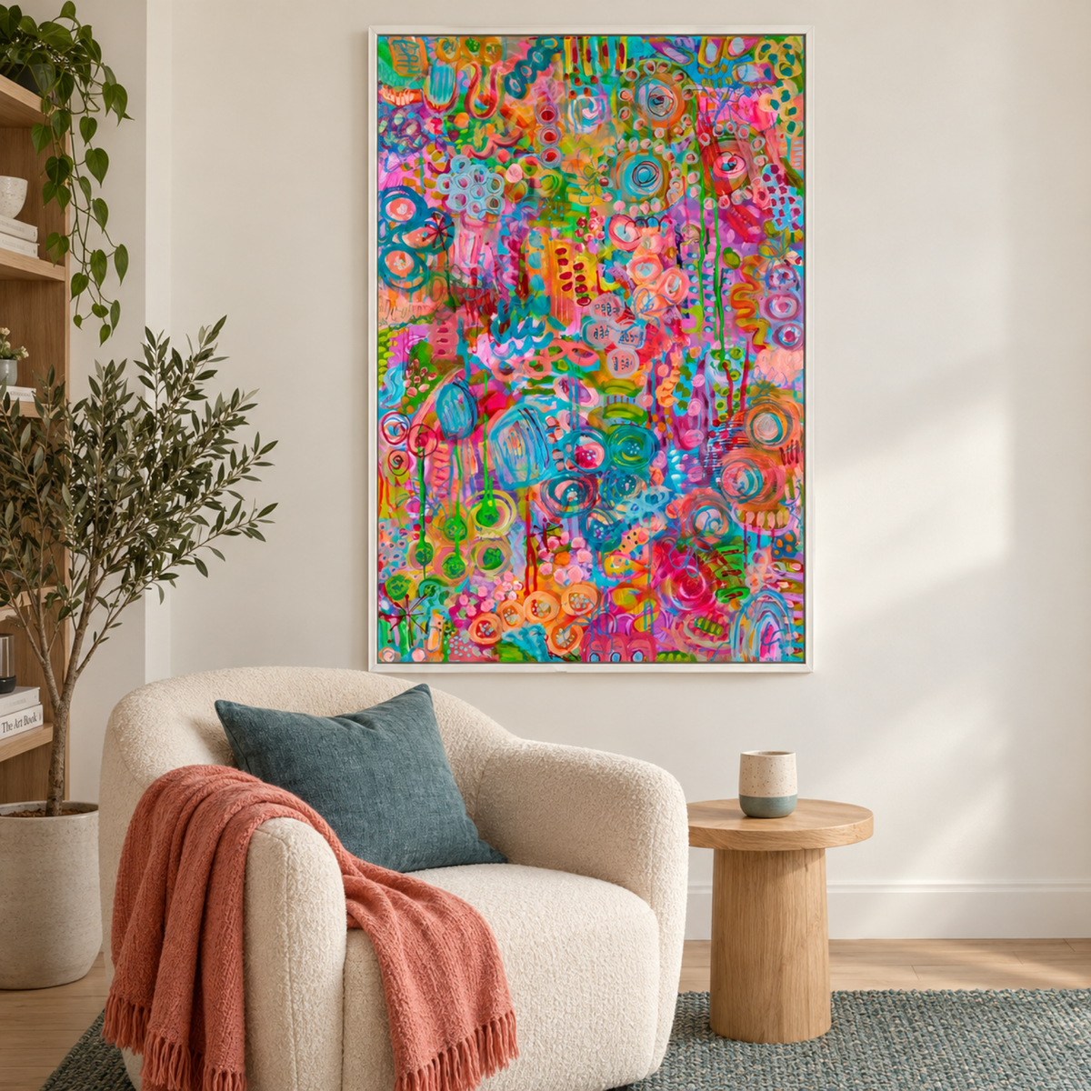 Withaflourish by Lindy Farley in a white frame above a cream armchair with teal and coral textiles.