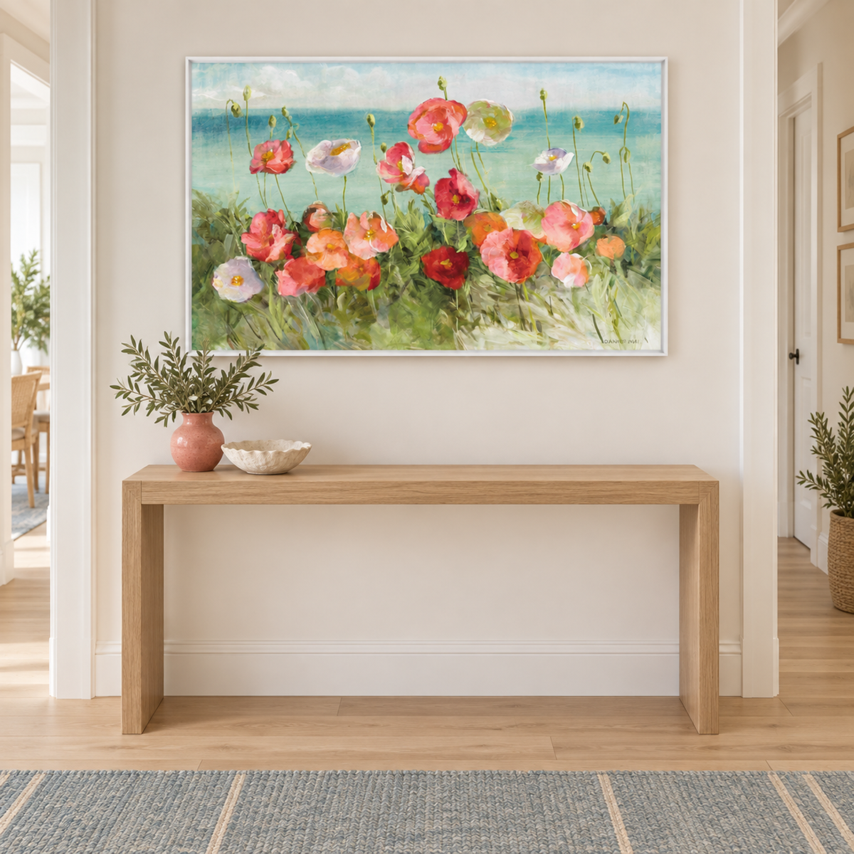 Coastal Poppies Light in a white frame above a light oak hallway console with coral and ivory ceramics.