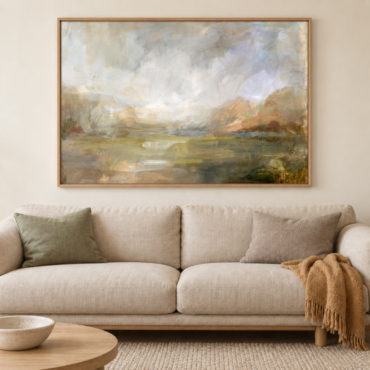 Misty Morning Vista in a natural oak frame above an oatmeal linen sofa with sage and grey cushions and an ochre throw.