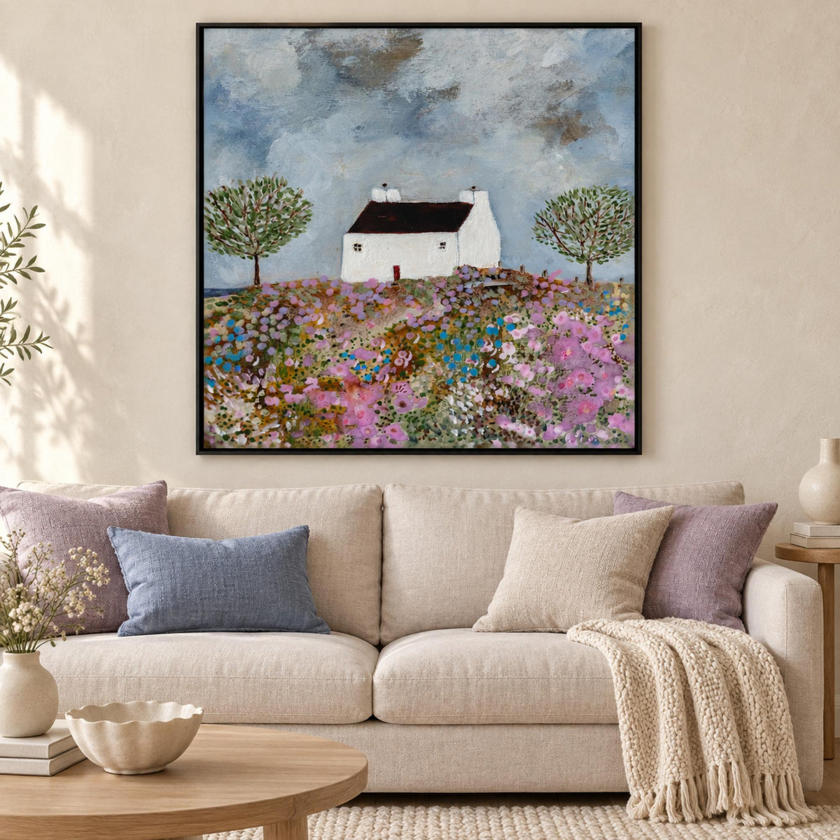 Secrets Of A Summer Meadow by Louise O’Hara in a black floating frame above a neutral sofa with blue and lilac cushions.