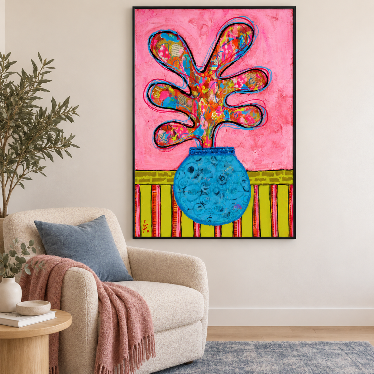 Splash of Life by Lindy Farley in a black frame in a cream reading corner with blue and rose textiles.