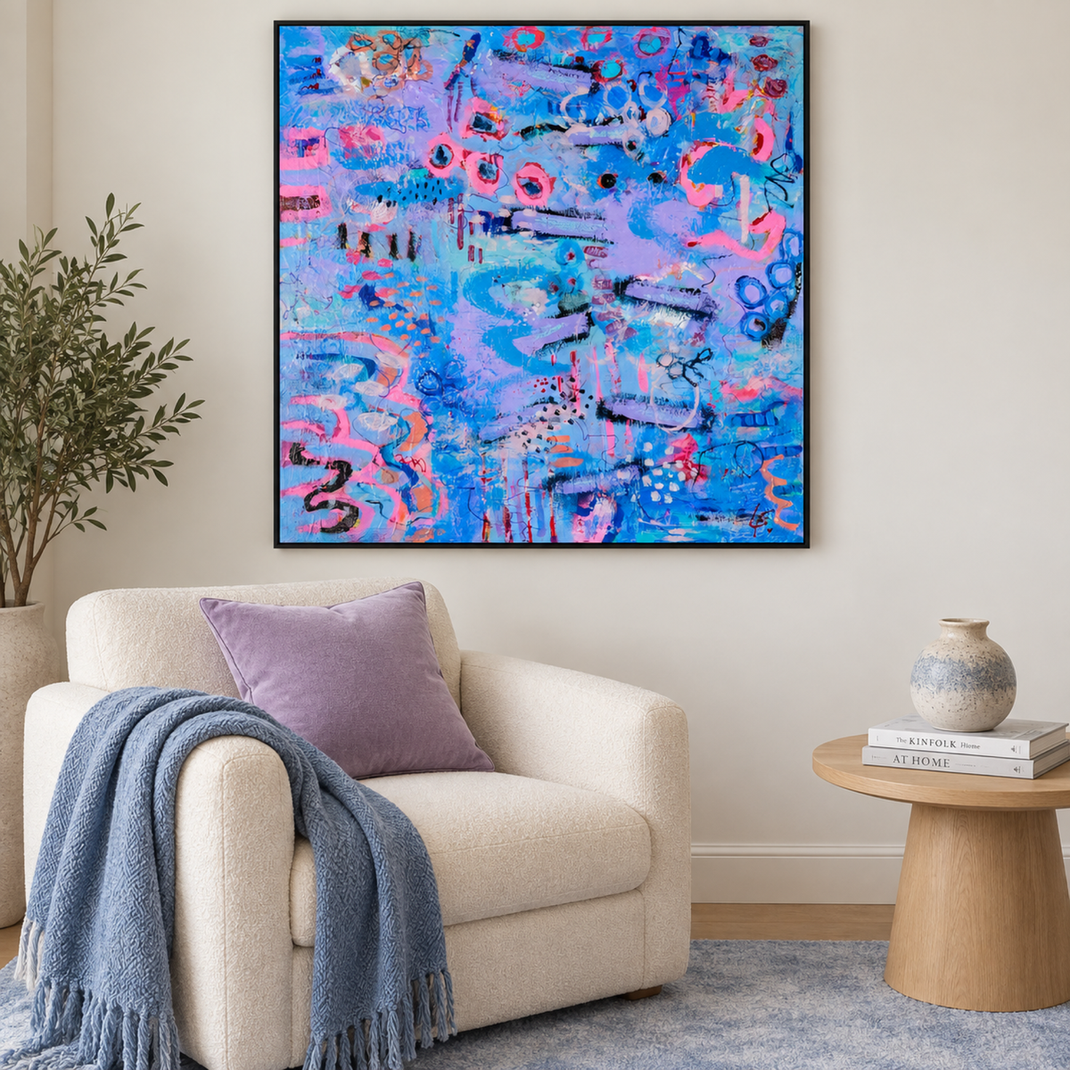 Untamed Wisteria by Lindy Farley in a black frame above a cream chair with lilac and blue textiles.